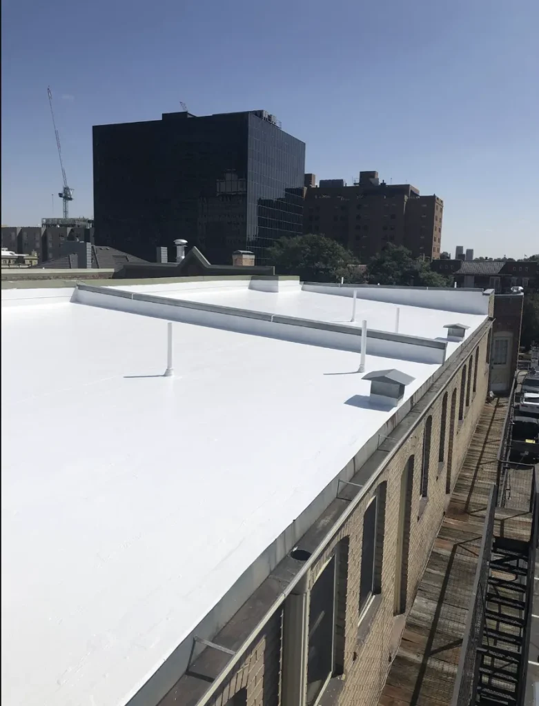 Commercial flat roof with new white coating overlooking nearby office buildings