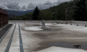 Aged commercial flat roof with ponding water and worn membrane before restoration