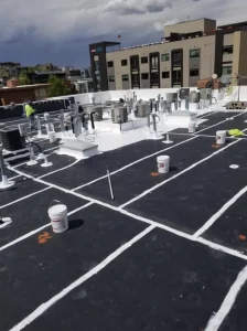 Black flat roof with white seam reinforcement during roof restoration