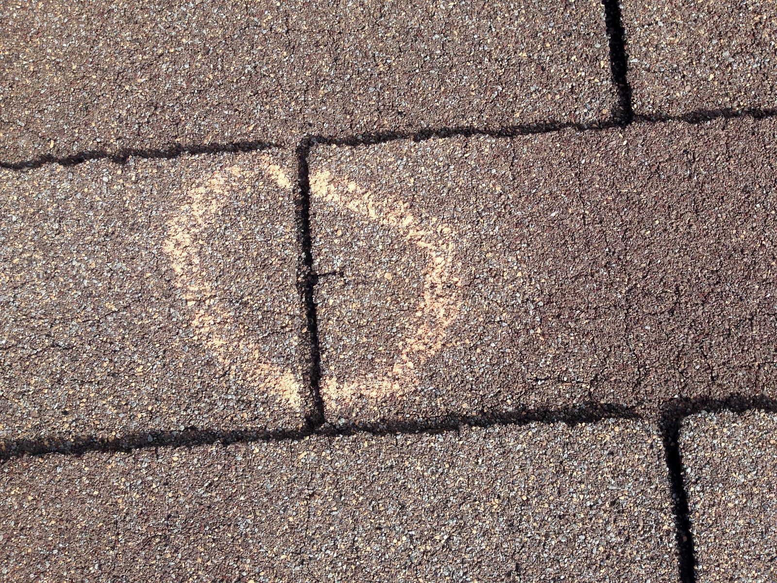 Roof with hail damage marked by an insurance adjuster